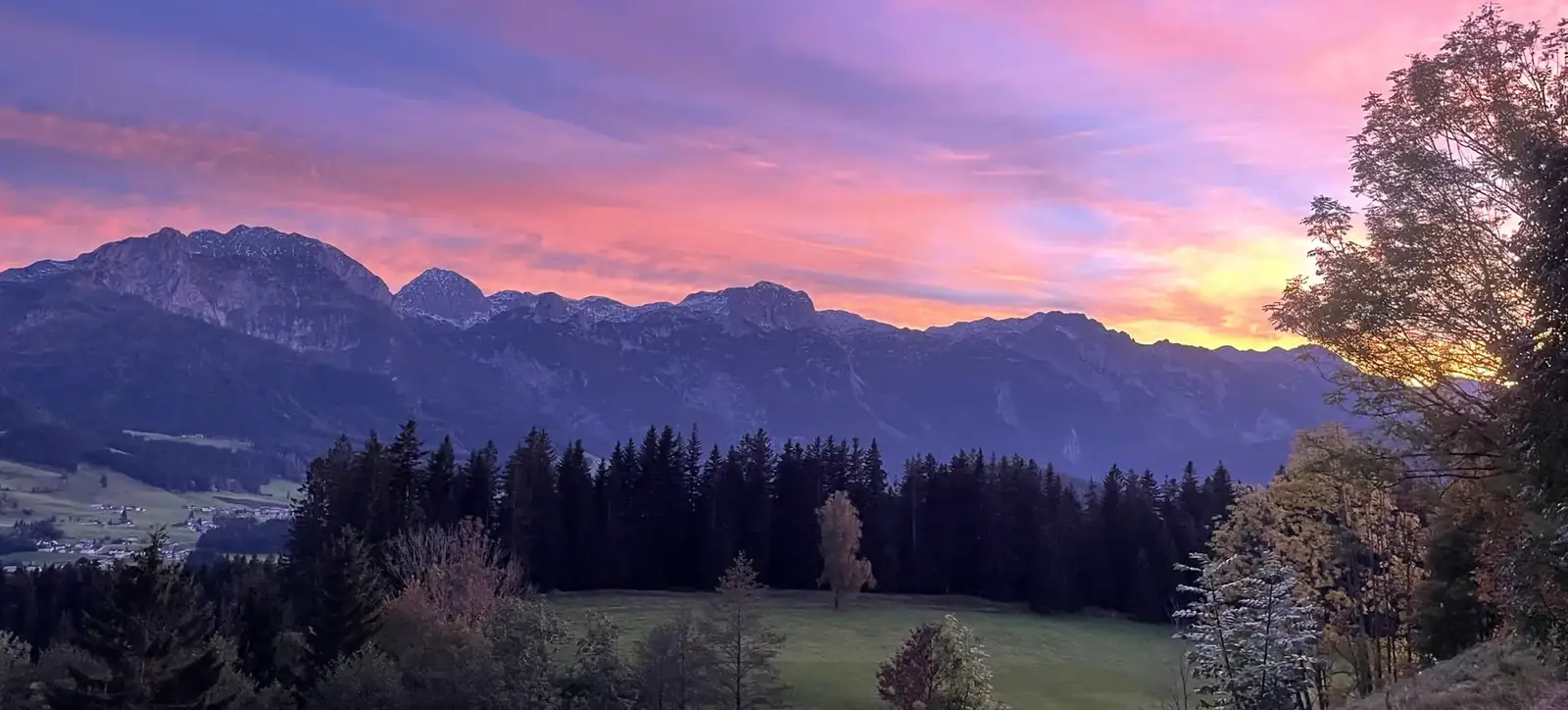 Abendrot über dem Tennengebirge, davor Wald und Wiesen