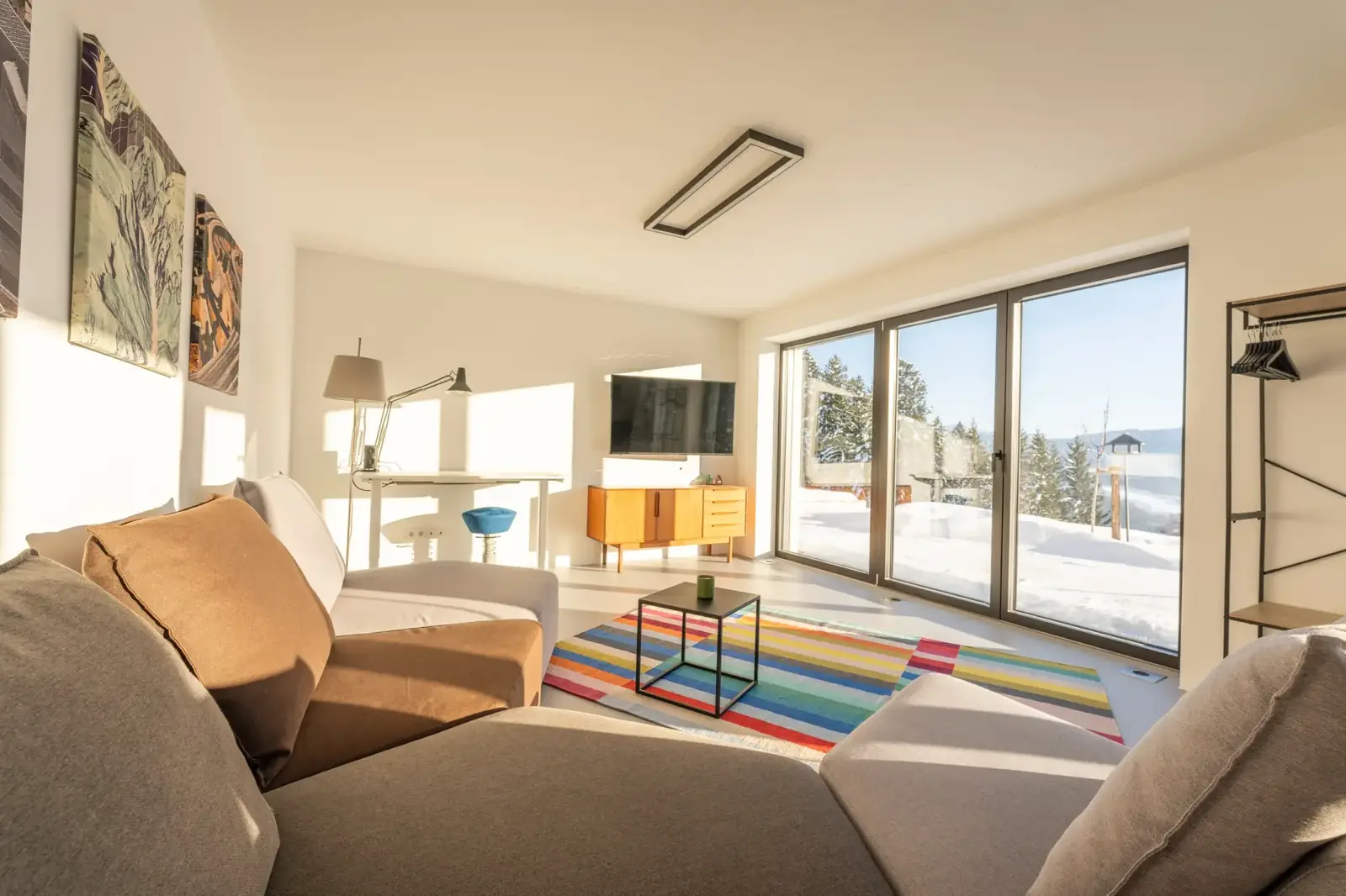 Sofa im Loft, durch die Fenster Schnee und Bergblick